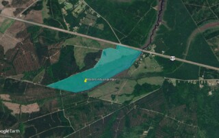 Aerial view of Mallard Industrial Park, highlighted in blue, borders Highway 82 and sits near Golden Isles Aerospace and Logistics, surrounded by forested and cleared land.