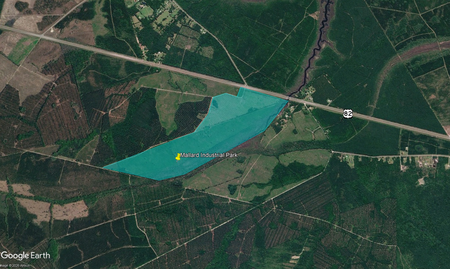 Aerial view of Mallard Industrial Park, highlighted in blue, borders Highway 82 and sits near Golden Isles Aerospace and Logistics, surrounded by forested and cleared land.